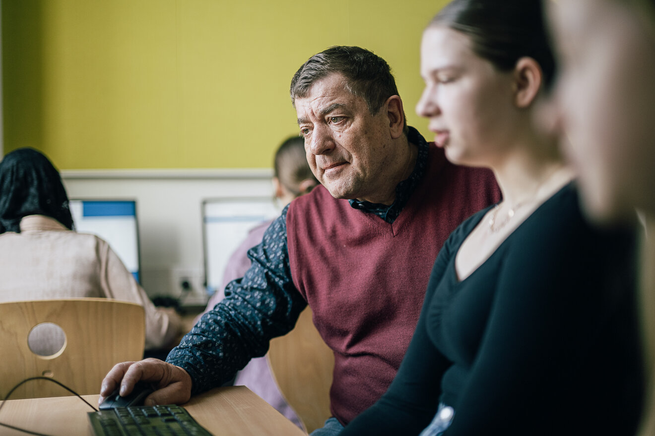 Lehrer und Schülerin beim Informatikunterricht