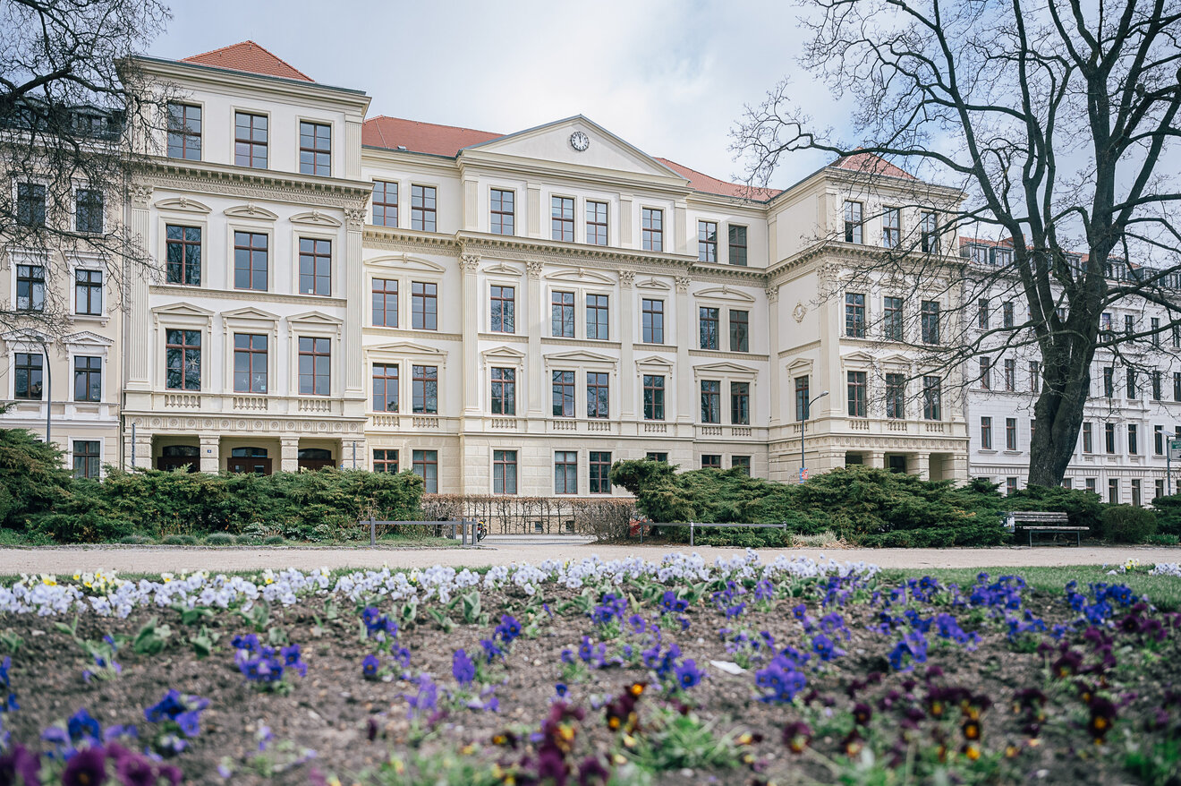 Aussenansicht des Joliot-Curie-Gymnasium im Frühling